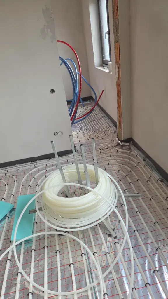 Țeavă PEX în spirale pe folie cu caroiaj, cu colacul de țeavă pe derulator